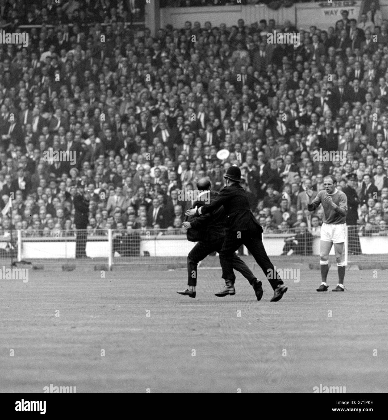 Es war ein Moment der wahnsinnigen Begeisterung während des FA Cup Finales in Wembley. Nachdem der Everton-Held Trebilcock sein zweites Tor erzielte, stürzte dieser Unterstützer auf das Feld und musste von der Polizei entfernt werden, beobachtet von Evertons Ray Wilson (rechts). Stockfoto