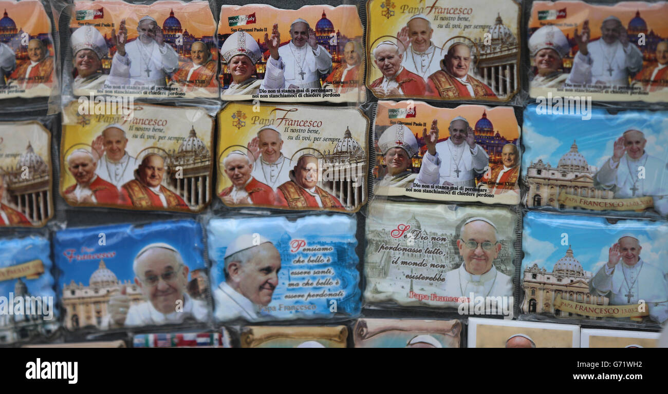 Geschenke zum Verkauf als Pilger aus aller Welt kommen auf den Petersplatz in der Vatikanstadt, um die Heiligsprechung der Päpste Johannes XXIII. Und Johannes Paul II. Zu sehen, die morgen Heilige werden. Stockfoto