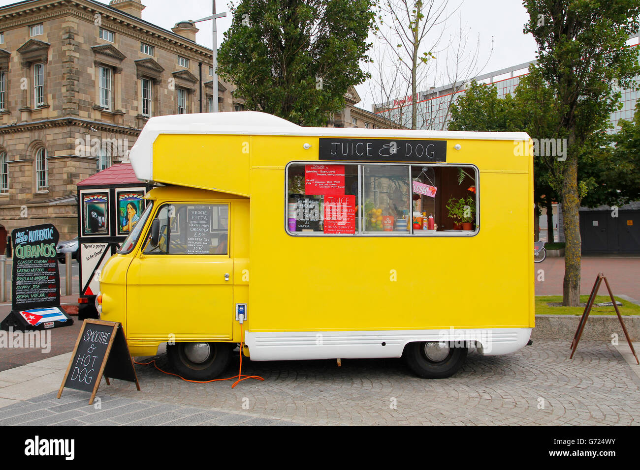 Gelbe Imbisswagen an natürliche Frucht Saft und vegetarische Speisen in der Straße geparkt Stockfoto