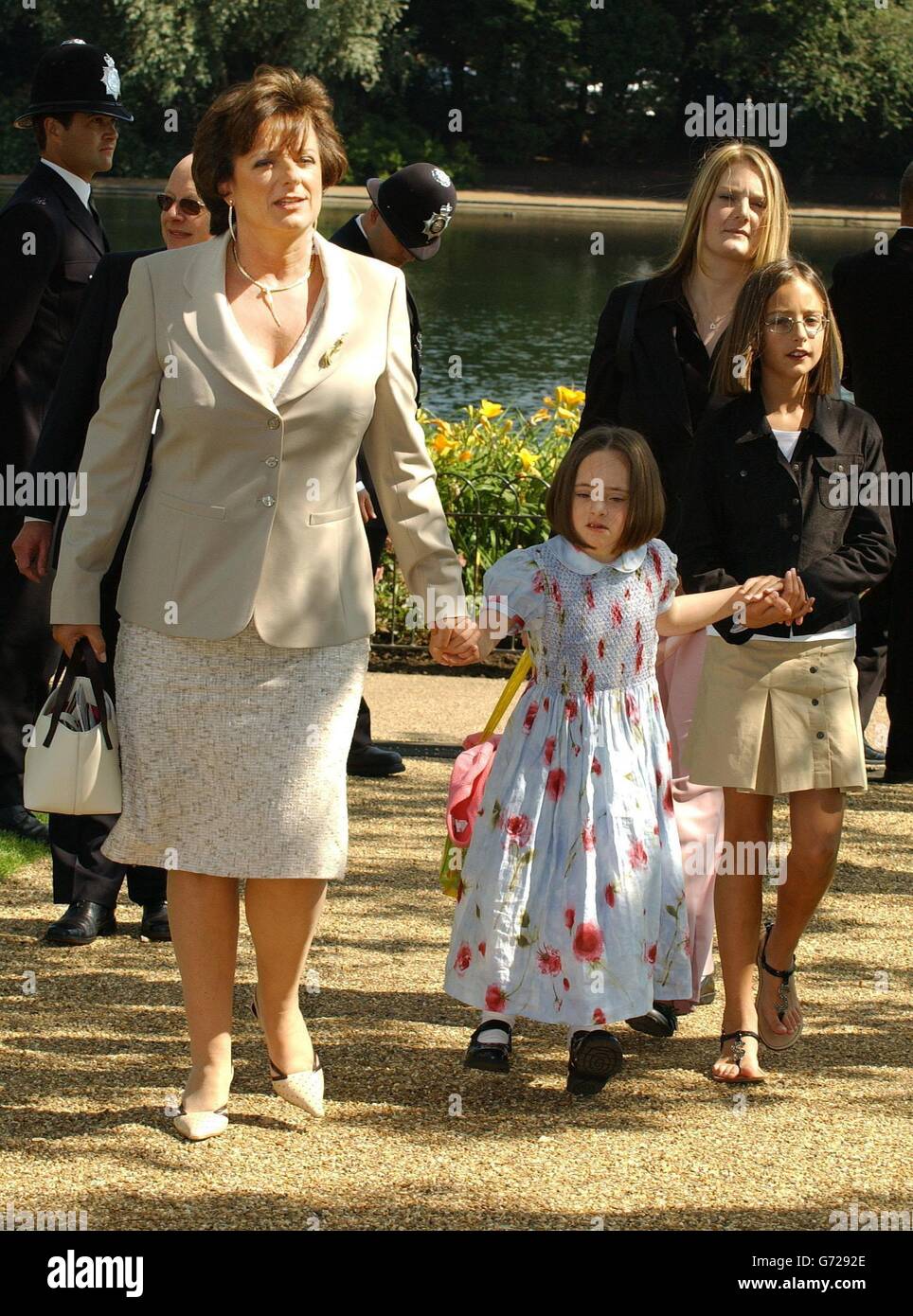 Die neunjährige Patenkind von Prinzessin Diana, Domenica Lawson (MITTE), überreichte der Königin einen Strauß rosa Rosen.Ihre Mutter, Rosa Monckton, links, die eine enge Freundin der Prinzessin und Vorsitzende des Memorial Fountain Committee war, sagte danach, als ihre Tochter im Wasser paddelte: "Ich bin einfach überwältigt. Stockfoto