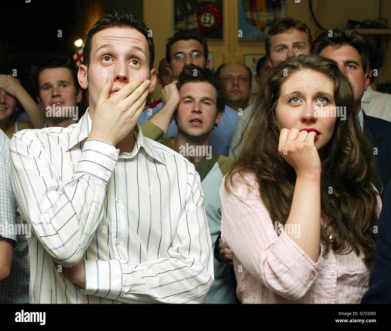 Englische Fans beim Spielen gegen Portugal im Viertelfinale der Euro 2004 auf der Großleinwand im schwer fassbaren Camel Pub in Victoria, London. Stockfoto