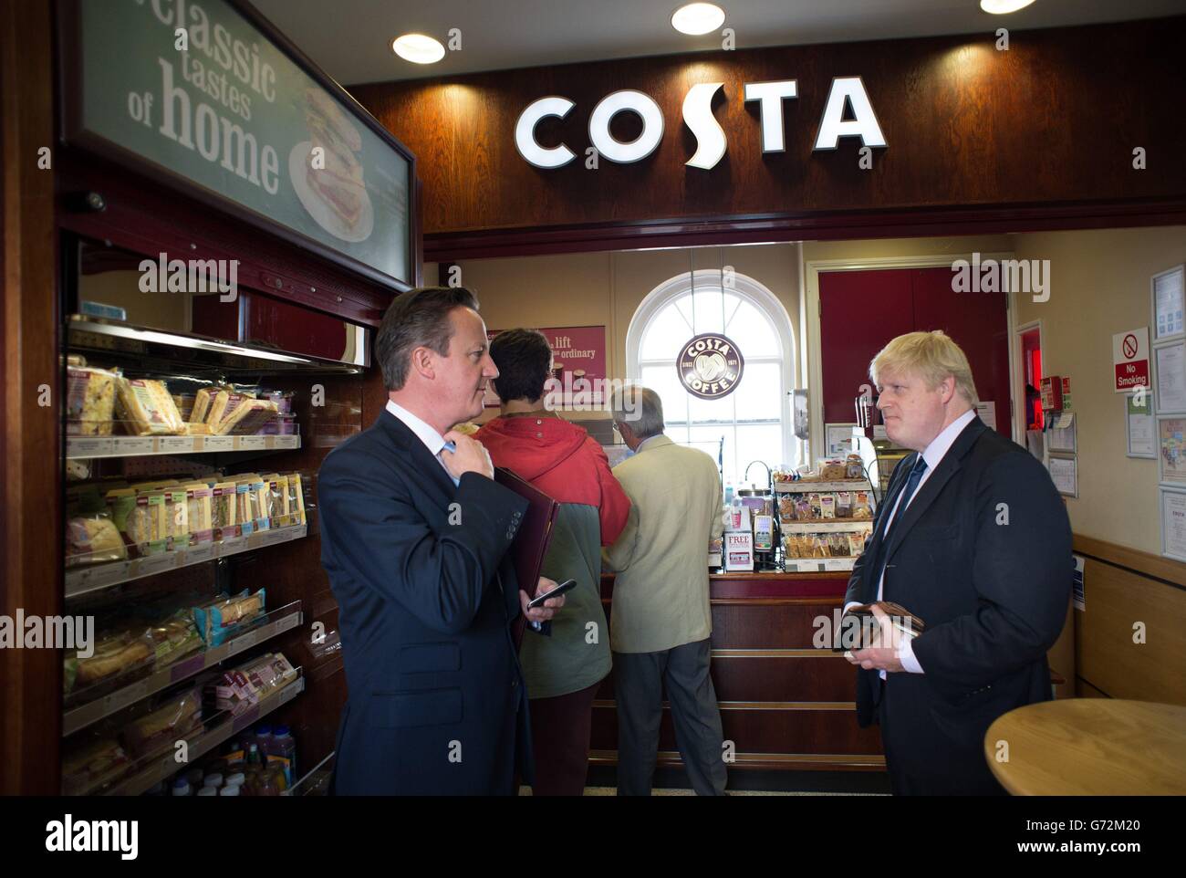 Premierminister David Cameron und der Bürgermeister von London, Boris Johnson, stehen nach einem Besuch in der Stadt in einem Café auf der Newark-Station für Kaffee an, wo sie vor den Nachwahlen, die am 5. Juni anstehen, für einen Wahlkampf werben. Stockfoto