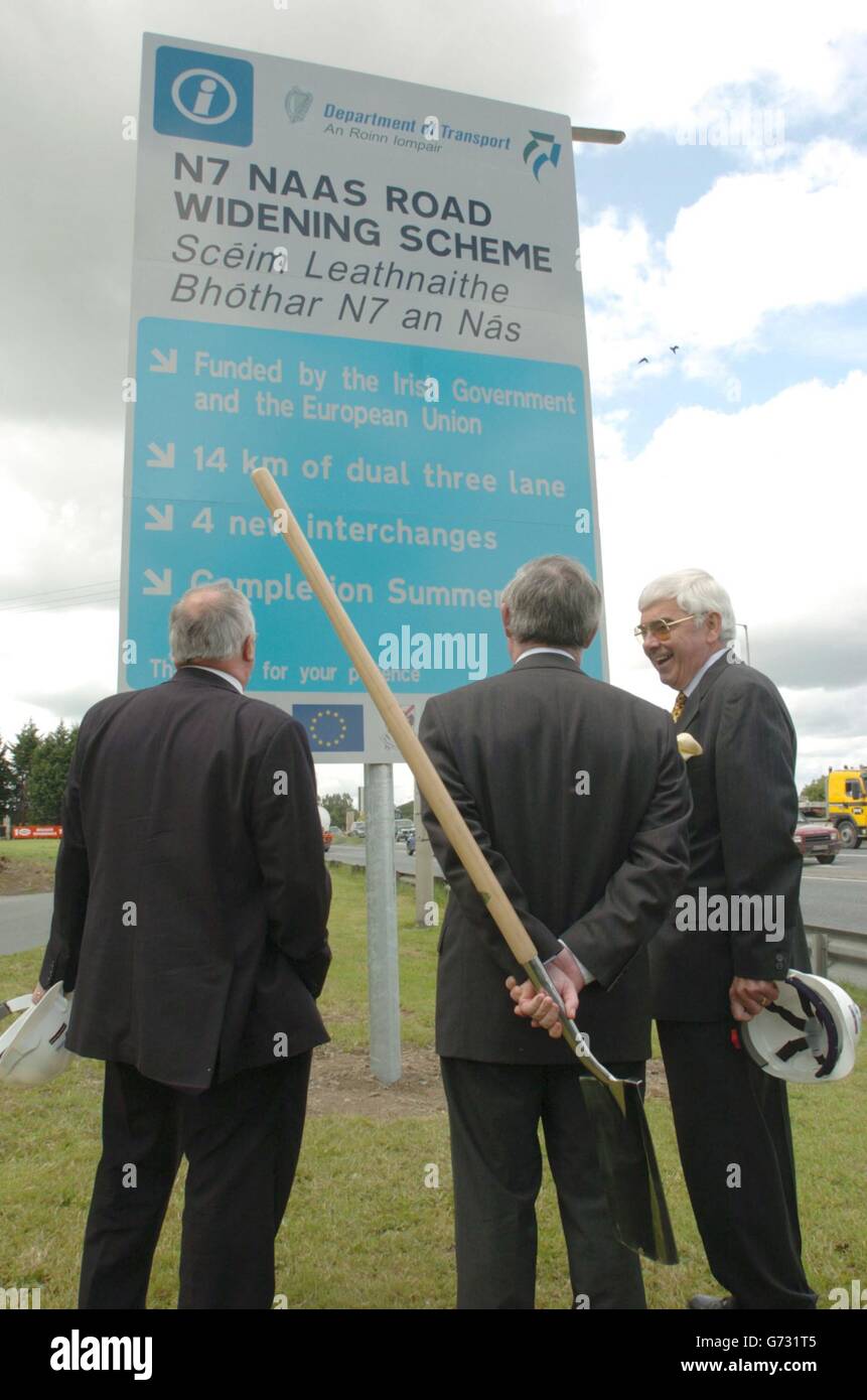Verkehrsminister Seamus Brennan (Mitte) mit Peter Malone (rechts), dem Vorsitzenden der National Roads Authority, und einem unbekannten Mann, bei einer Zeremonie, bei der er den ersten Spatenstich für den Baubeginn der 230 Millionen Euro teuren Naas Road in Kill, Co. Kildare, Irland, machte. Die bestehende zweispurige Fahrbahn N7 wird auf 3 Fahrspuren zwischen Rathcoole und dem Naas-By-Pass erweitert, die Fertigstellung wird voraussichtlich im Frühjahr 2006 erfolgen. Das Projekt besteht aus zwei Abschnitten, wobei der Kildare-Abschnitt 8.75 km lang ist und der South Dublin-Abschnitt 5,5 km lang ist. Stockfoto