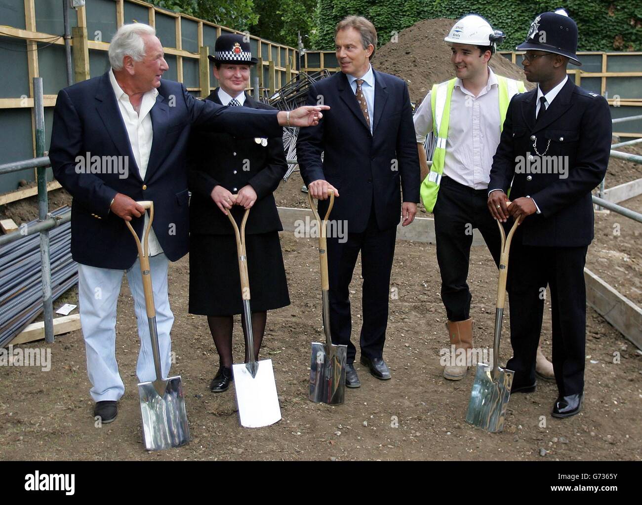 Premierminister Tony Blair (Mitte) spricht mit (von links nach rechts) Michael Water, dem Greater Manchester Police Constable Lynn Bialowas, dem Standortleiter Bernard Franklin und dem Metropolitan Police Constable Joel Edwards bei einem Besuch des National Police Memorial, Whitehall, London. Die Gedenkstätte wird im Oktober 2004 zum Gedenken an britische Polizeibeamte eröffnet, die im Laufe des Dienstes getötet wurden, und ist die Idee des Gründers des Police Memorial Trust, Michael Winners. Stockfoto