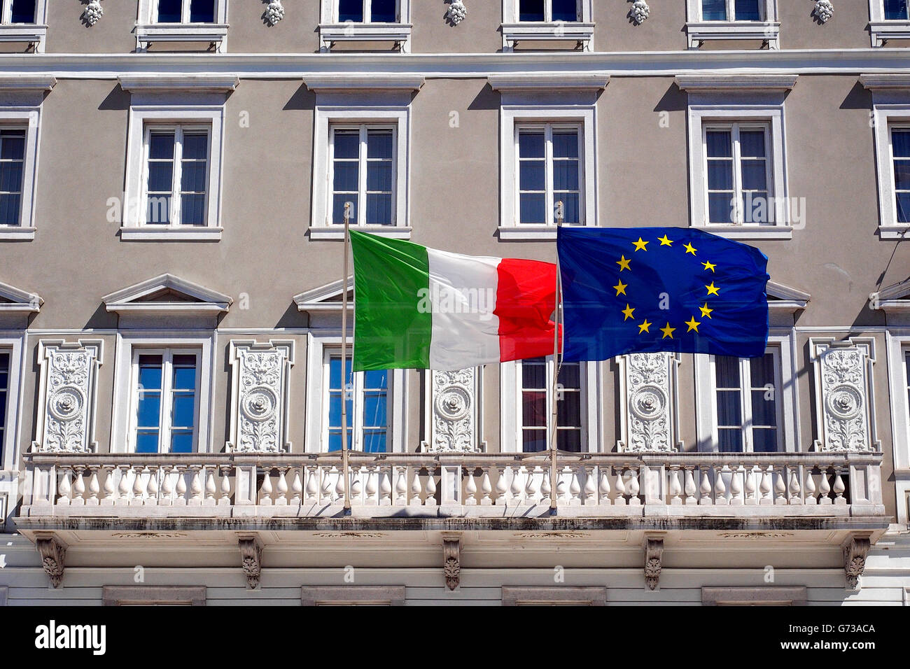 Italienisch und vereintes Europa Flaggen wehten auf dem Balkon eines historischen Gebäudes. Stockfoto