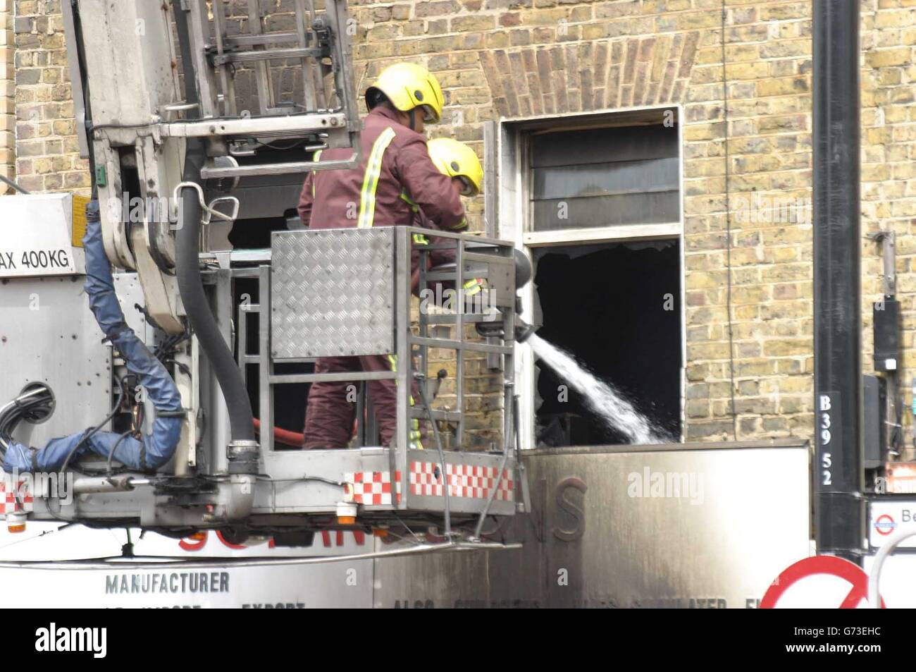 Feuerwehrleute feuern weiterhin ein dreistöckiges Gebäude in Bethnal Green im Osten Londons an, wo zwei Kollegen bei einem Brand ums Leben kamen. Es wird verstanden, dass sich die beiden im obersten Stockwerk des Gebäudes befanden, das im Erdgeschoss einen Laden und darüber Wohnungen hatte, als es schien, dass der Boden unter ihnen seinen Platz eingab. Sie wurden schwer verletzt und eilten ins Krankenhaus, wo sie anschließend beide starben. Stockfoto