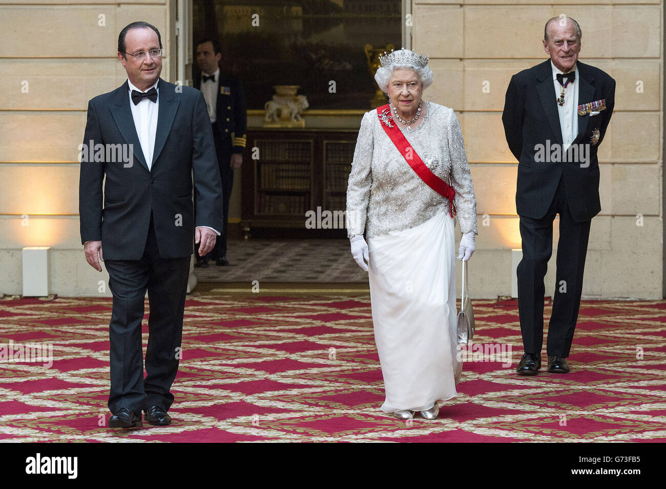 Präsident Francois Hollande von Frankreich (links) spaziert mit Königin Elizabeth II. Und dem Herzog von Edinburgh, während sie an einem Staatsbankett im Elysee Palace, Paris, im Rahmen des Staatsbesuchs der Königin in Frankreich teilnehmen. Stockfoto