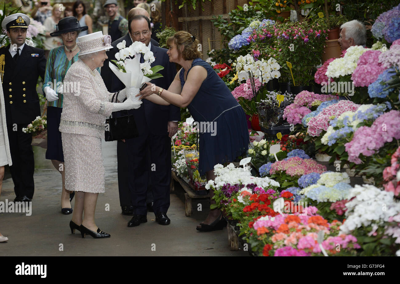Königin Elizabeth II. Erhält Blumen, als sie auf dem Blumenmarkt nach Marche aux Fleurs - reine Elizabeth II. Geht, in der Nähe der Kathedrale Notre Dame in Paris, während ihr dreitägiger Staatsbesuch in Frankreich zu Ende geht Stockfoto