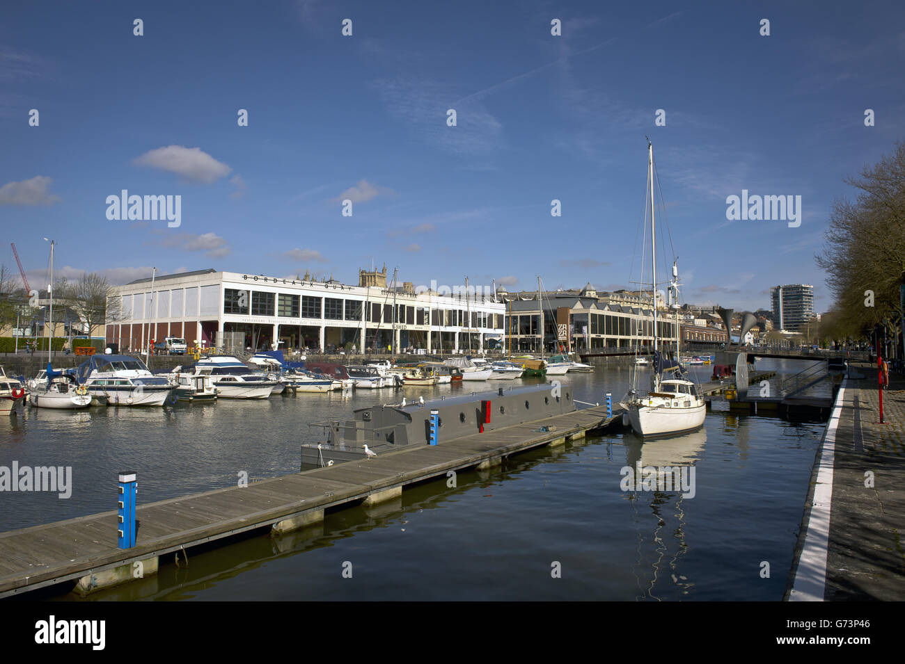 Bristol Harbour mit Blick auf die Anlegestellen und Bars am Wasser und Nachtclubs im Hafen der Stadt Bristol. Es existiert seit dem 13. Jahrhundert, wurde aber zu Beginn des 19. Jahrhunderts zu seiner heutigen Form weiterentwickelt, indem es Schleusentore auf einem Gezeitenabschnitt des Flusses Avon im Zentrum der Stadt installierte und einen Gezeitenumlauf für den Fluss zur Verfügung stellte. Er wird als schwimmender Hafen bezeichnet, da der Wasserstand konstant bleibt und er nicht vom Gezeitenzustand auf dem Fluss beeinflusst wird Stockfoto