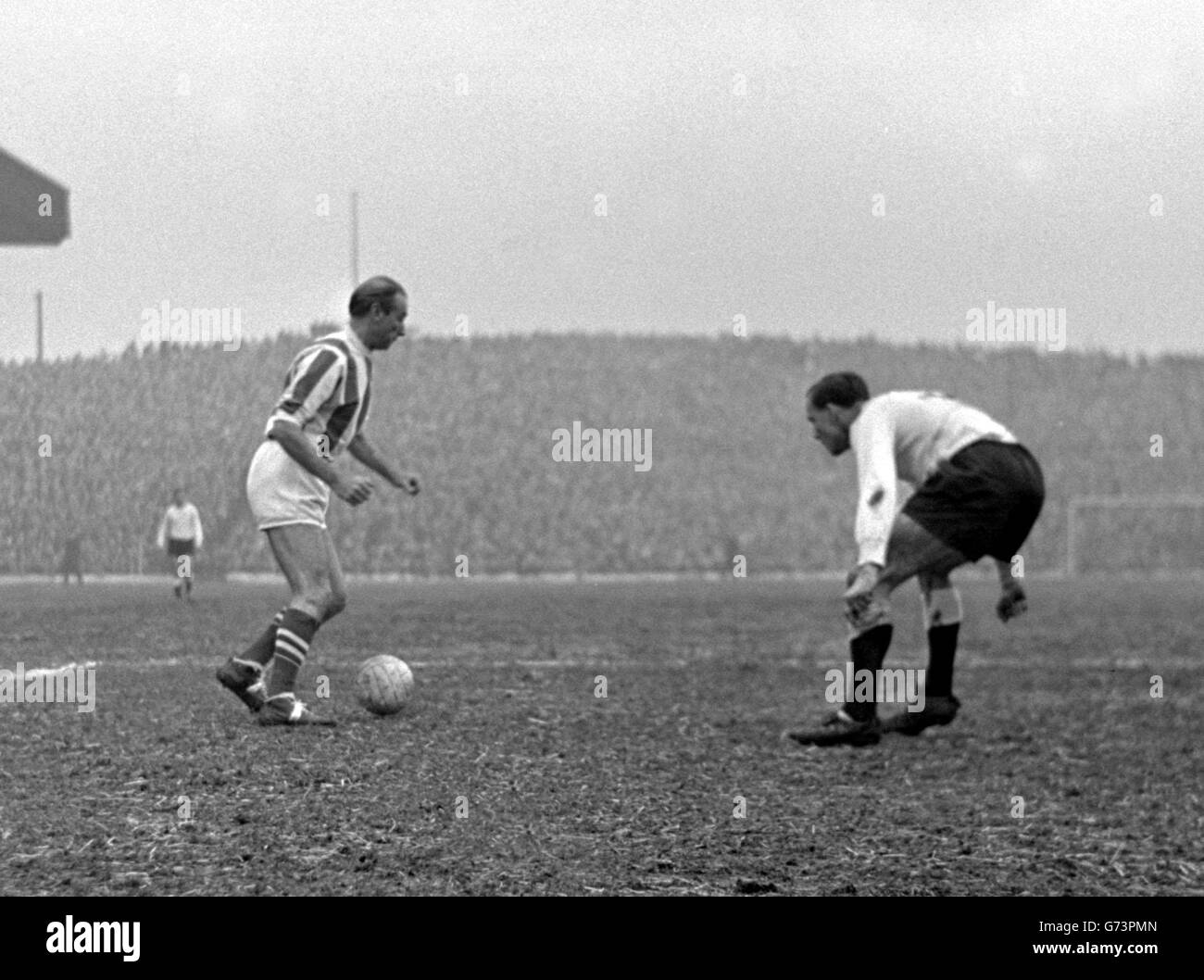 Könnte es ein Fall sein, je mehr er sieht, desto weniger wird er sehen? Die 50-jährigen Füße des äußeren rechten Zauberers Stanley Matthews behalten ihre Magie still, und Fulham links-zurück Langley (der 36 ist) hält seine Augen auf sie in dieser Konfrontation während der First Division Spiel in Stoke vernietet. Matthew, dessen gloriusreiche Fußballkarriere in einer Ritterschaft gipfelte, machte seinen Auftritt in der 699. Liga. Er verhalf Stoke City zu einem Sieg von 3-1. Stockfoto