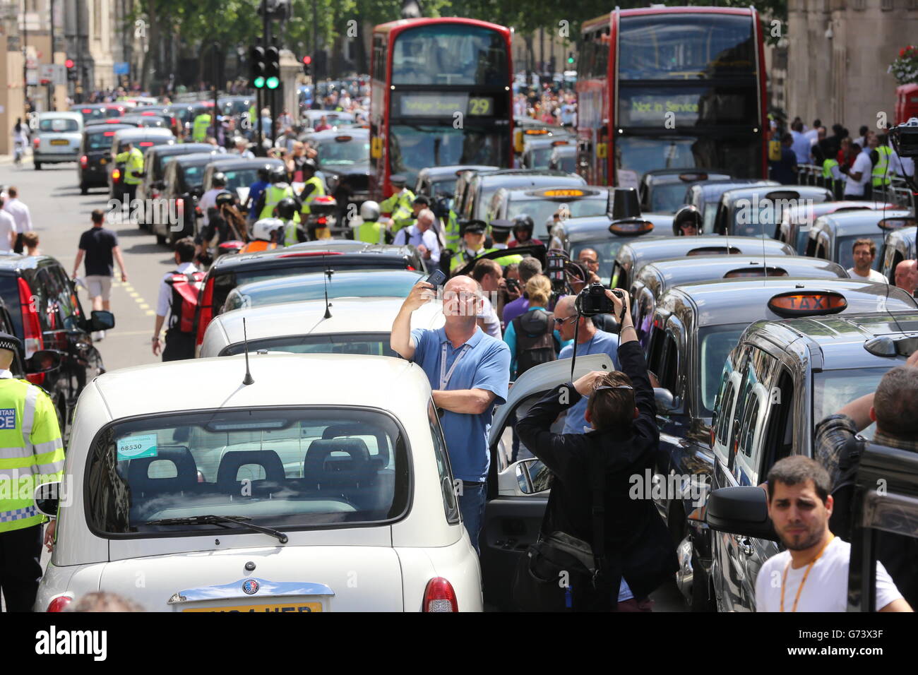 Schwarze Taxifahrer und lizenzierte Taxifahrer protestieren am Trafalgar Square in London über die Einführung einer Telefon-App namens Uber, mit der Kunden Fahrzeuge buchen und verfolgen können. Stockfoto