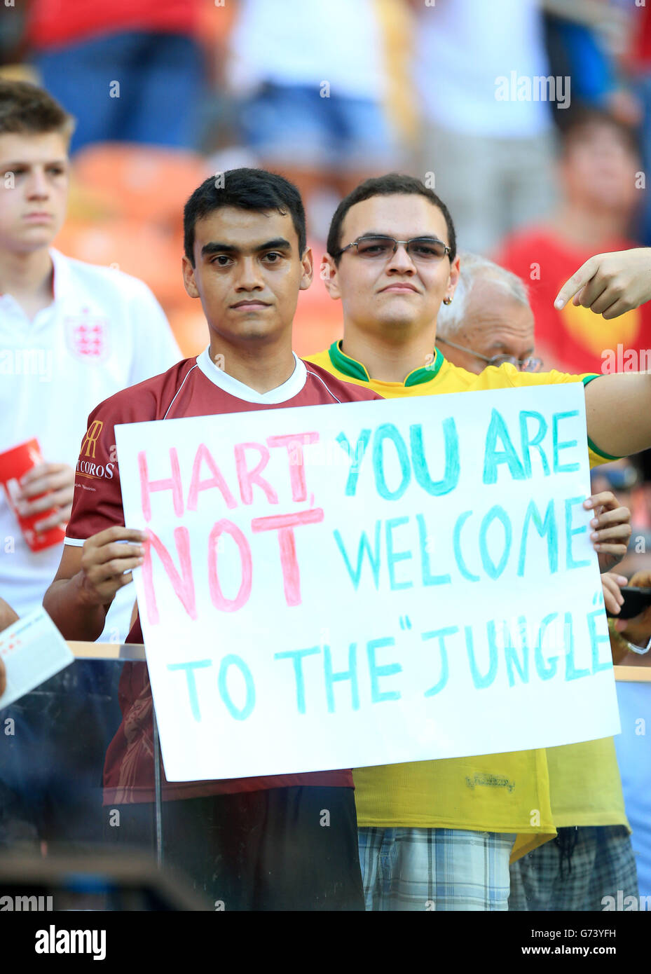 Fußballfans auf den Tribünen halten ein Banner mit der Aufschrift „Hart, You are Not Welcome to the „Jungle“ hoch, bevor sie das Spiel der FIFA-Weltmeisterschaft der Gruppe D in der Arena da Amazonia, Manaus, Brasilien, starten. Stockfoto