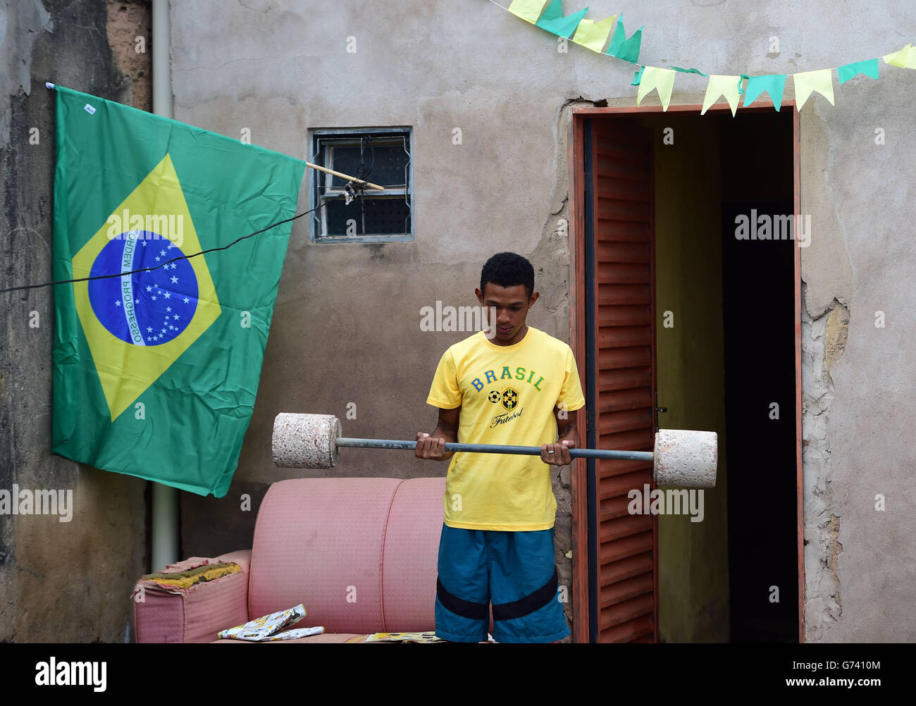 Ein Brasilien-Fan macht ein bisschen Gewichtheben in seinem Vorgarten Stockfoto