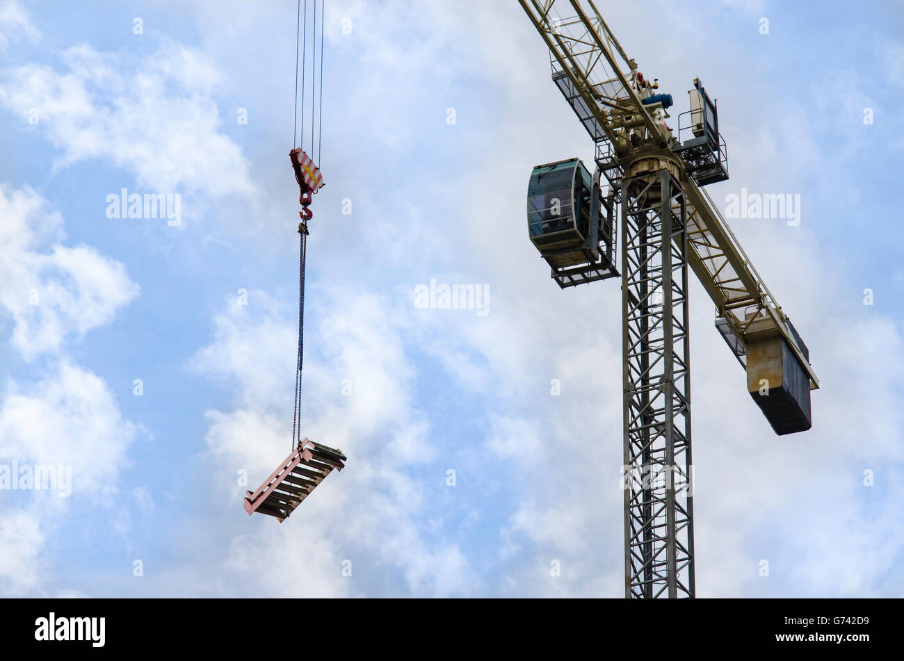 Auf der Suche an einem Kran wie bewegt er sich ein Stück Alu Gerüst (Schritte) über eine Baustelle Stockfoto