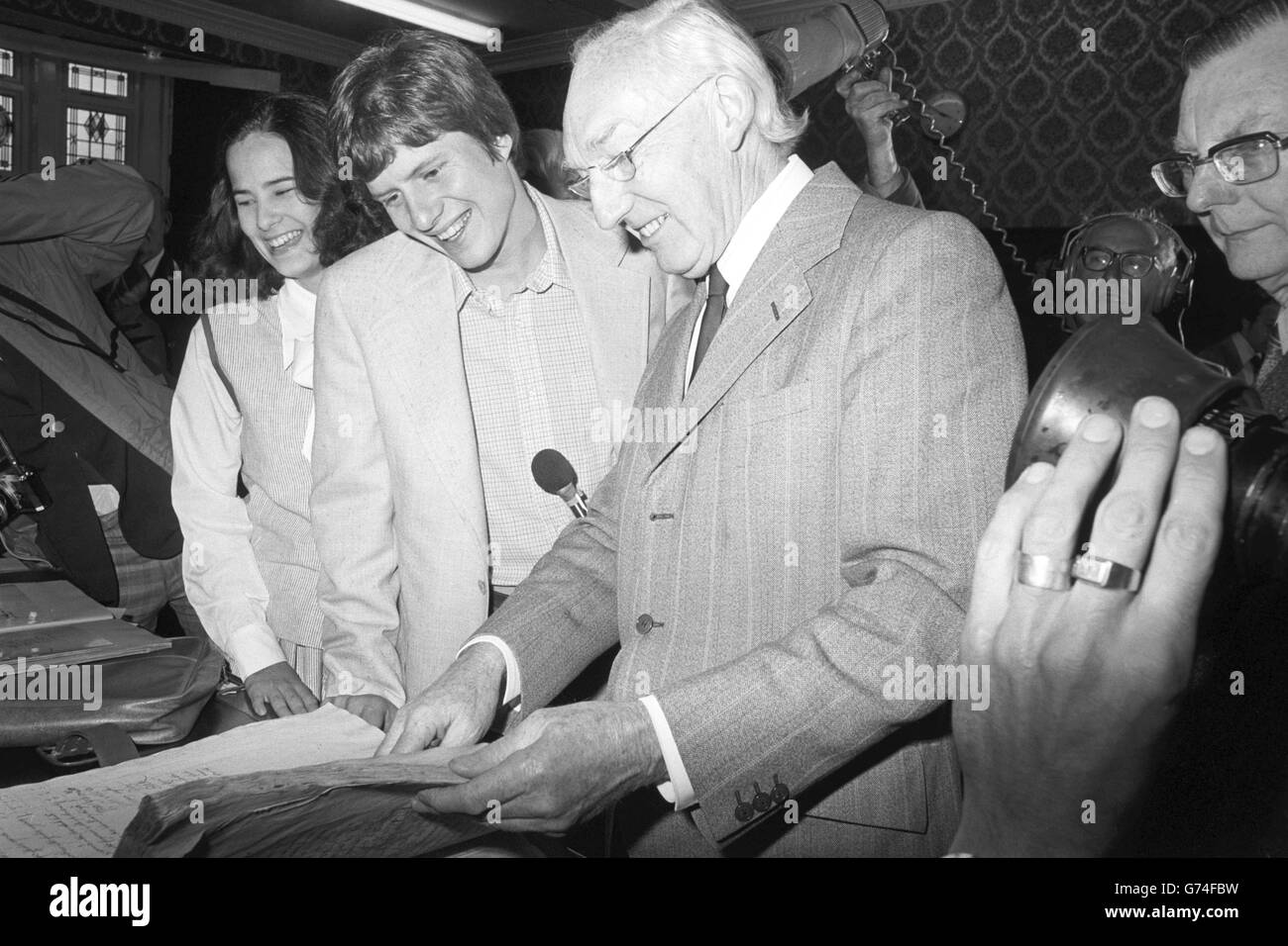 Präsident Jimmy Carters Sohn Chip und seine Frau Caron werden Dokumente des lokalen Historikers Allen White bei einem Besuch in Christchurch in Dorset gezeigt. Die Carters waren vermutlich im 17. Jahrhundert aus der Region nach Amerika aufgesetzt. Chip sagte, der Besuch in Christchurch sei für mich das "Highlight der ganzen Reise". Das Paar war sieben Tage lang in Großbritannien, um das Silberne Jubiläum zu feiern. Stockfoto