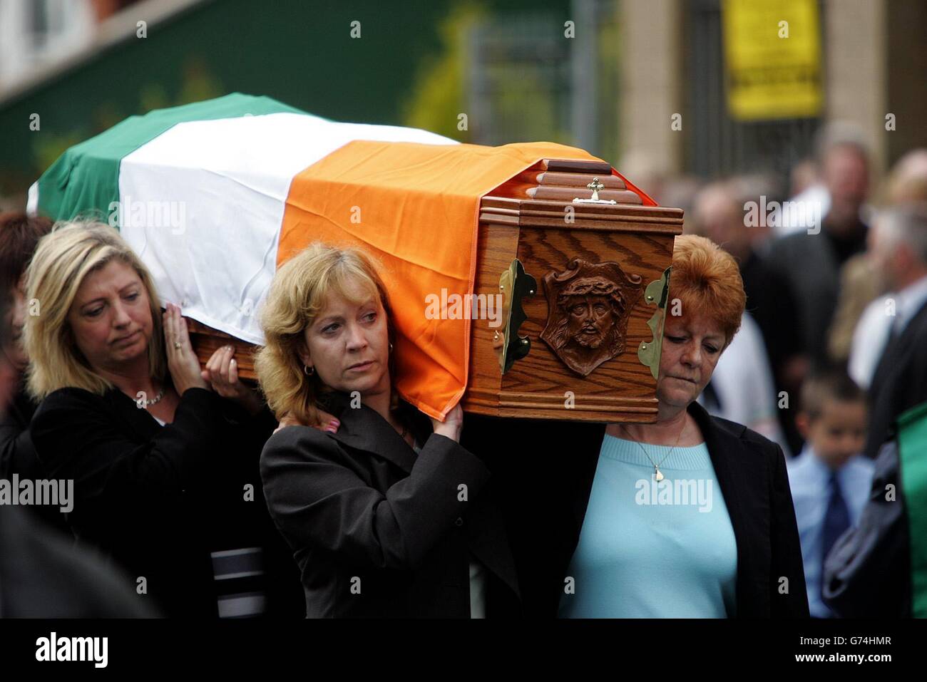 Freunde und Verwandte tragen den Sarg des altgedienten Republikaners Joe Cahill auf dem Weg zur St. John's Church auf der Falls Road in die Andersontown Road. Der stellvertretende Parteivorsitzende und ehemalige IRA-Stabschef Cahill starb am Wochenende an einer Asbestose im Alter von 84 Jahren, und seine Beerdigung brachte West-Belfast zum Stillstand. Adams sagte den Republikanern am Grab von Cahill, dass Elemente innerhalb der britischen Regierung für die Blockade des Friedensprozesses verantwortlich seien. Stockfoto