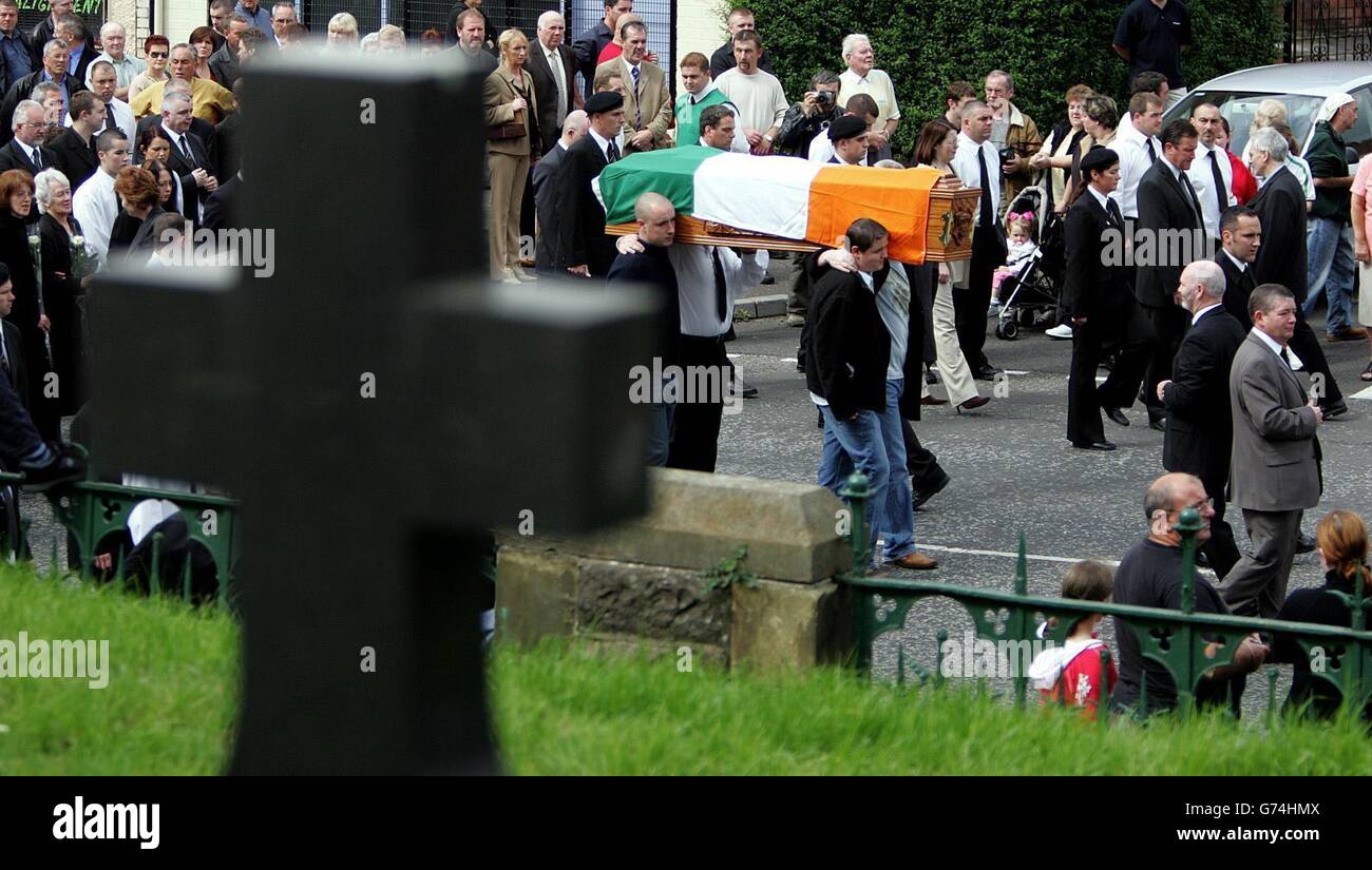 Einheimische beobachten, wie der Sarg des altgedienten Republikaners Joe Cahill auf dem Weg zur St John's Church auf der Falls Road an der Andersontown Road Police Service Northern Ireland Station vorbeiführt. Parteivizepräsident und ehemaliger IRA-Stabschef Cahill starb am Wochenende an Asbestose im Alter von 84 Jahren und seine Beerdigung brachte West-Belfast zum Stillstand. Adams sagte den Republikanern am Grab von Cahill, dass Elemente innerhalb der britischen Regierung für die Blockade des Friedensprozesses verantwortlich seien. Stockfoto