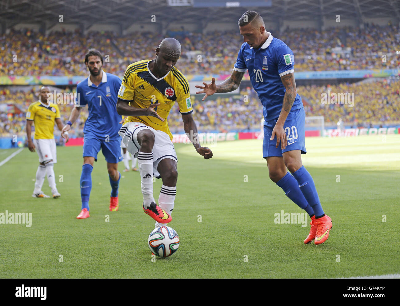 Kolumbiens Victor Ibarbo und Griechenlands Jose Holebas Kampf um den Ball während der Gruppe C WM Fußball match zwischen Kolumbien und Griechenland im Mineirão Stadion in Belo Horizonte, Brasilien, Samstag, 14. Juni 2014. (AP Photo/Frank Augstein) Stockfoto