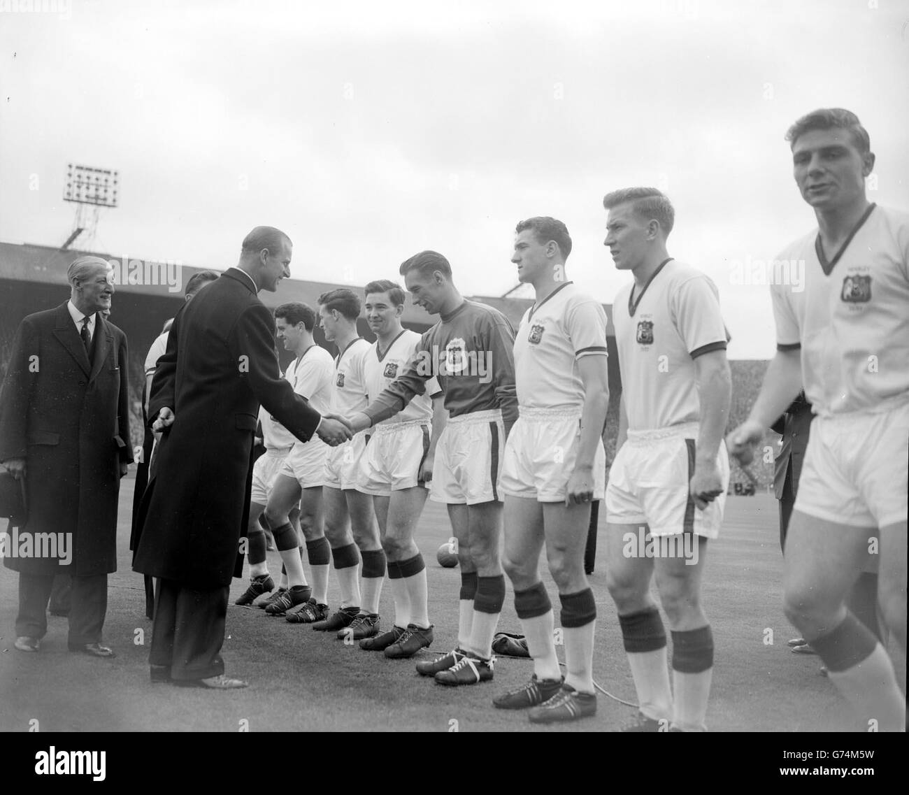 Der Duke of Edinburgh schüttelt sich lächelnd die Hände mit Torwart Ray Wood, als ihm das Team von Manchester United vor dem Start des FA Cup Finales gegen Aston Villa auf dem Spielfeld im Empire Stadium, Wembley, präsentiert wird. Wood war ro haben ein Pech match. Er wurde bei einem Zusammenstoß mit Peter McParland, nur etwa sieben Minuten nach dem Start, verletzt und auf einer Bahre getragen, während jackie Blanchflower seinen Platz im Tor belegte. Villa gewann 2:1. Stockfoto