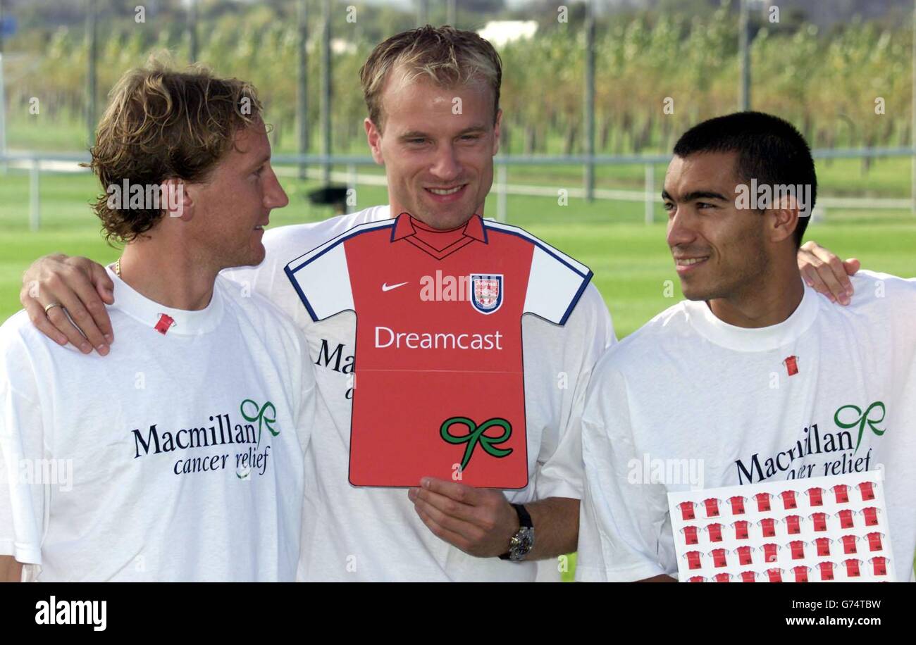 Die Arsenal-Spieler Dennis Bergkamp (Mitte), Giovani van Bronckhorst (rechts) und Ray Parlor (links) hefteten neue Farben an ihre Brust, um das vierte Jahr der Unterstützung ihres Clubs für Macmillan Cancer Relief zu starten. Die Arsenal-Pin-Abzeichen sind für eine vorgeschlagene Spende von je 1 im Club und in den JJB Sports-Outlets erhältlich, und das gesamte Geld, das gesammelt wird, wird für die Finanzierung der Spezialdienste von Macmillan verwendet, die dazu beitragen, das Leben von Krebspatienten und ihren Familien zu erleichtern und unnötige Ängste zu reduzieren. . Stockfoto