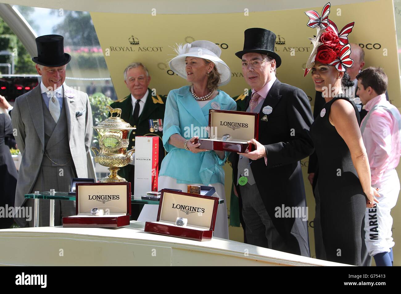 Der Prinz von Wales, Prinz Charles, überreicht Besitzer Lord Lloyd-Webber (rechts) und Baroness Lloyd-Webber mit einer Trophäe, nachdem die Fuge den Prince of Wales's Stakes am zweiten Tag des Royal Ascot Meetings 2014 auf der Ascot Racecourse, Berkshire gewonnen hatte. Stockfoto