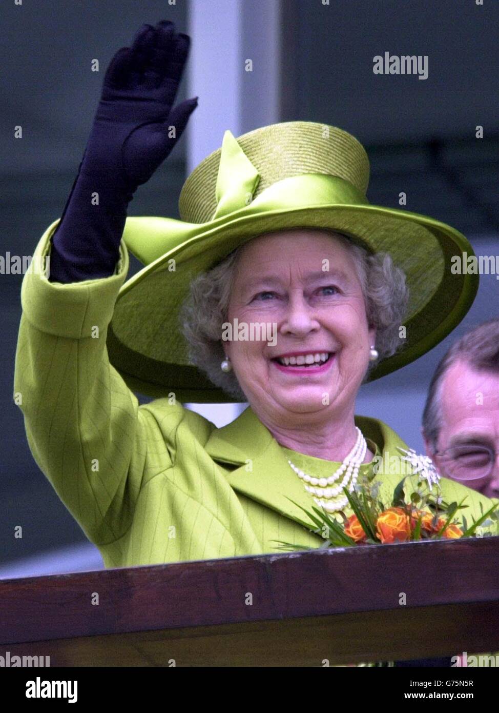 Queen Elizabeth II winkt der Menge in Epsom Downs, 2002, zum Lauf des Derby zu. * 7/8/02: Die Sommerfeiern des Goldenen Jubiläums der Königin enden mit einer Gartenparty im Balmoral in den schottischen Highlands. Es ist der Höhepunkt einer 14-wöchigen Reise in alle Regionen des Vereinigten Königreichs. Seit Mai haben die Königin und der Herzog von Edinburgh 70 Städte und Städte in 50 Grafschaften in England, Schottland, Wales und Nordirland besucht. Die überwältigende öffentliche Resonanz auf die landesweite Jubiläumstour hat sogar die Königin überrascht, die sagte, sie sei zutiefst berührt von der Stockfoto