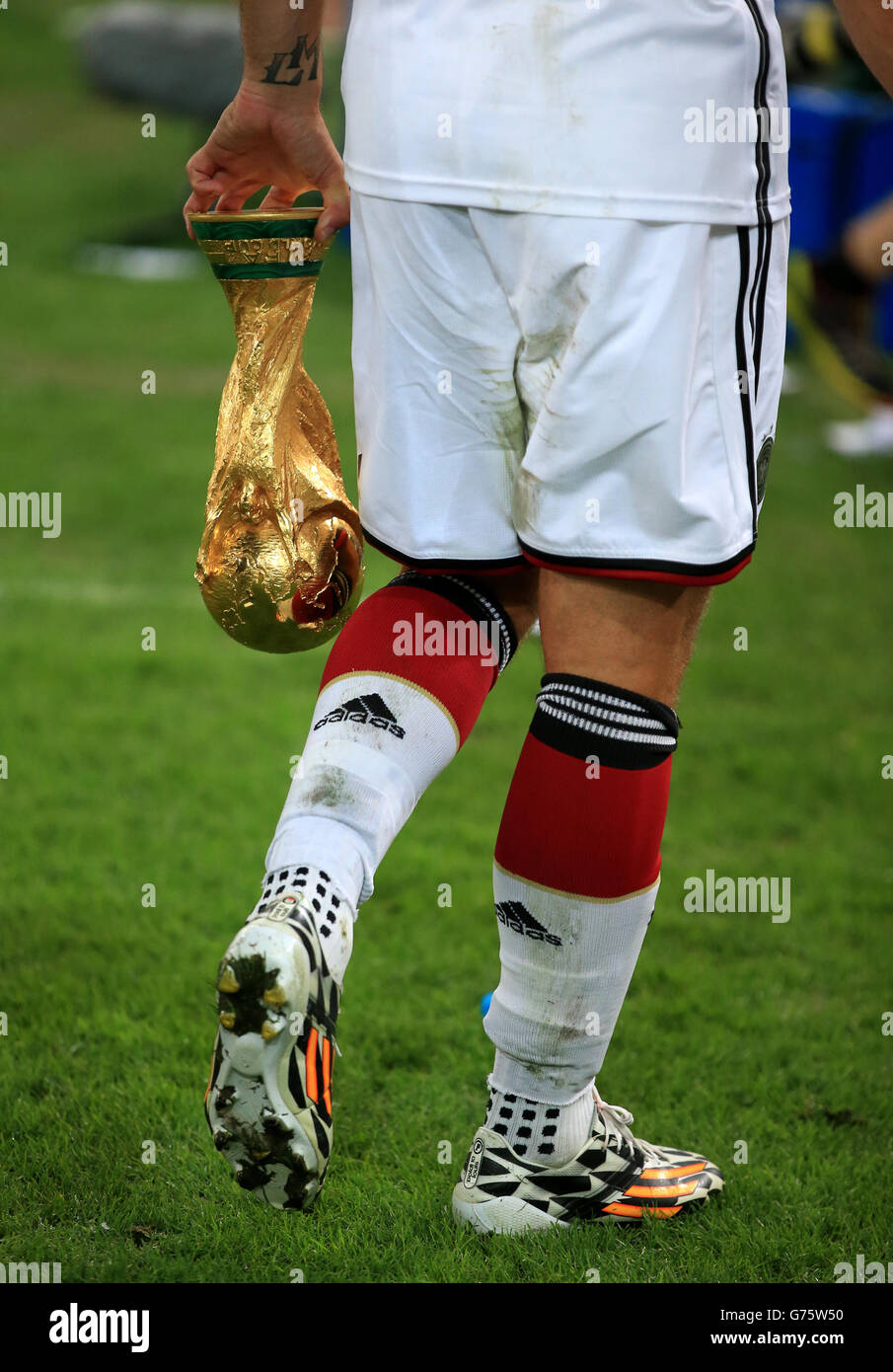 Der deutsche Lukas Podolski trägt die FIFA World Cup Trophy ...