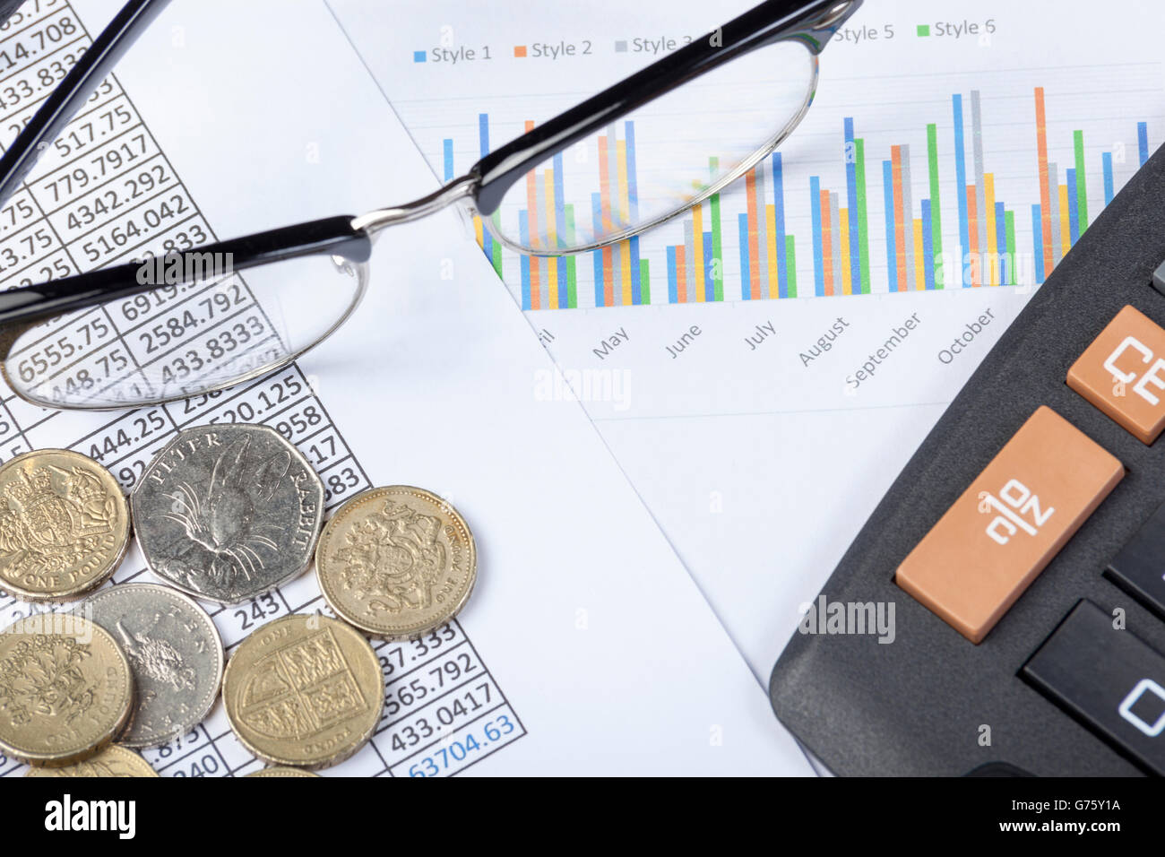 Brille und einen Rechner zusammen mit einige Bargeld-nung auf einen Buchhalter Schreibtisch auf einer Tabellenkalkulation und Grafik Stockfoto