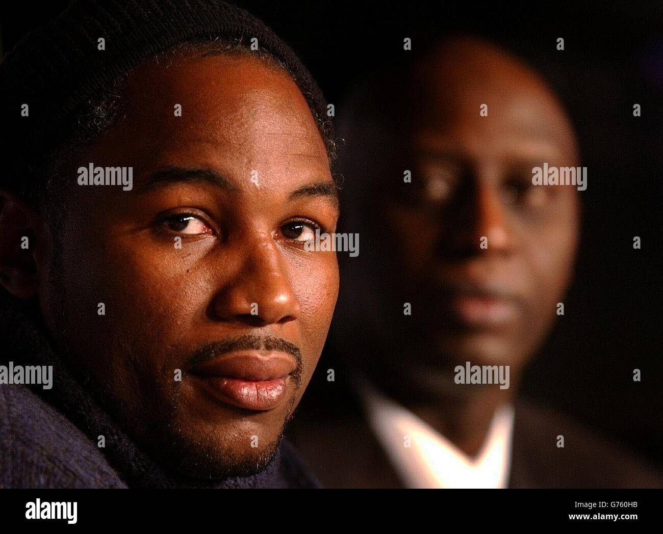 Lennox Lewis, mit Manager Adrian Ogun (R) auf einer Pressekonferenz im Leicester Square, im Zentrum von London, gibt seine Reaktion auf die Nachricht, dass sein World Heavyweight Boxing Titel Kampf gegen Mike Tyson wird nicht Schieß los. in Las Vegas im April. Stockfoto