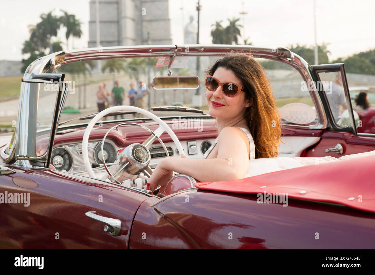 Eine Frau posiert in einem Oldtimer in Havanna, Kuba Stockfoto