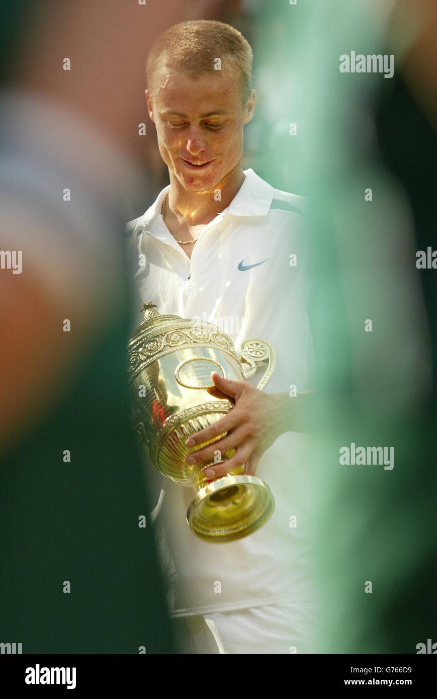 KEINE KOMMERZIELLE NUTZUNG. Der weltbeste Aussaat Lleyton Hewitt aus Australien umarmt die Trophäe, nachdem er David Nalbandian aus Argentinien beim Finale der Herren-Singles in Wimbledon besiegt hat. Die Tennismeisterschaften im All England Lawn Tennis Club ist das erste Mal, dass Nalbandian auf dem Rasen Tennis gespielt hat. Hewitt gewann in den geraden Sätzen 6:1/6:3/6:2. Stockfoto