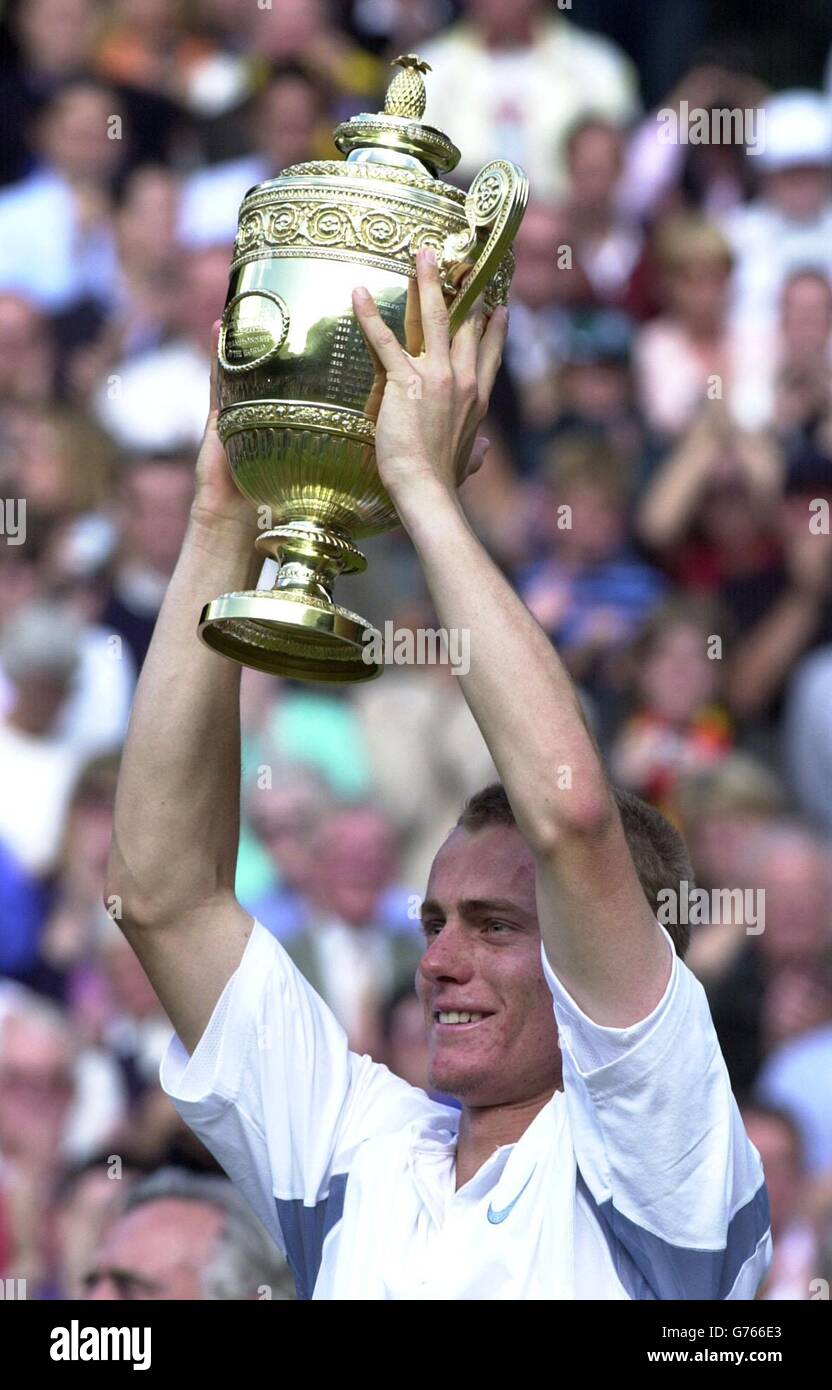 KEINE KOMMERZIELLE NUTZUNG. Der weltbeste Aussaat Lleyton Hewitt aus Australien hebt die Trophäe an, nachdem er David Nalbandian aus Argentinien beim Finale der Herren-Singles in Wimbledon besiegt hat. * die Tennis-Meisterschaften im All England Lawn Tennis Club ist das erste Mal, dass Nalbandian Wettbewerb Grass Court Tennis gespielt hat. Hewitt gewann in den geraden Sätzen 6:1/6:3/6:2. Stockfoto