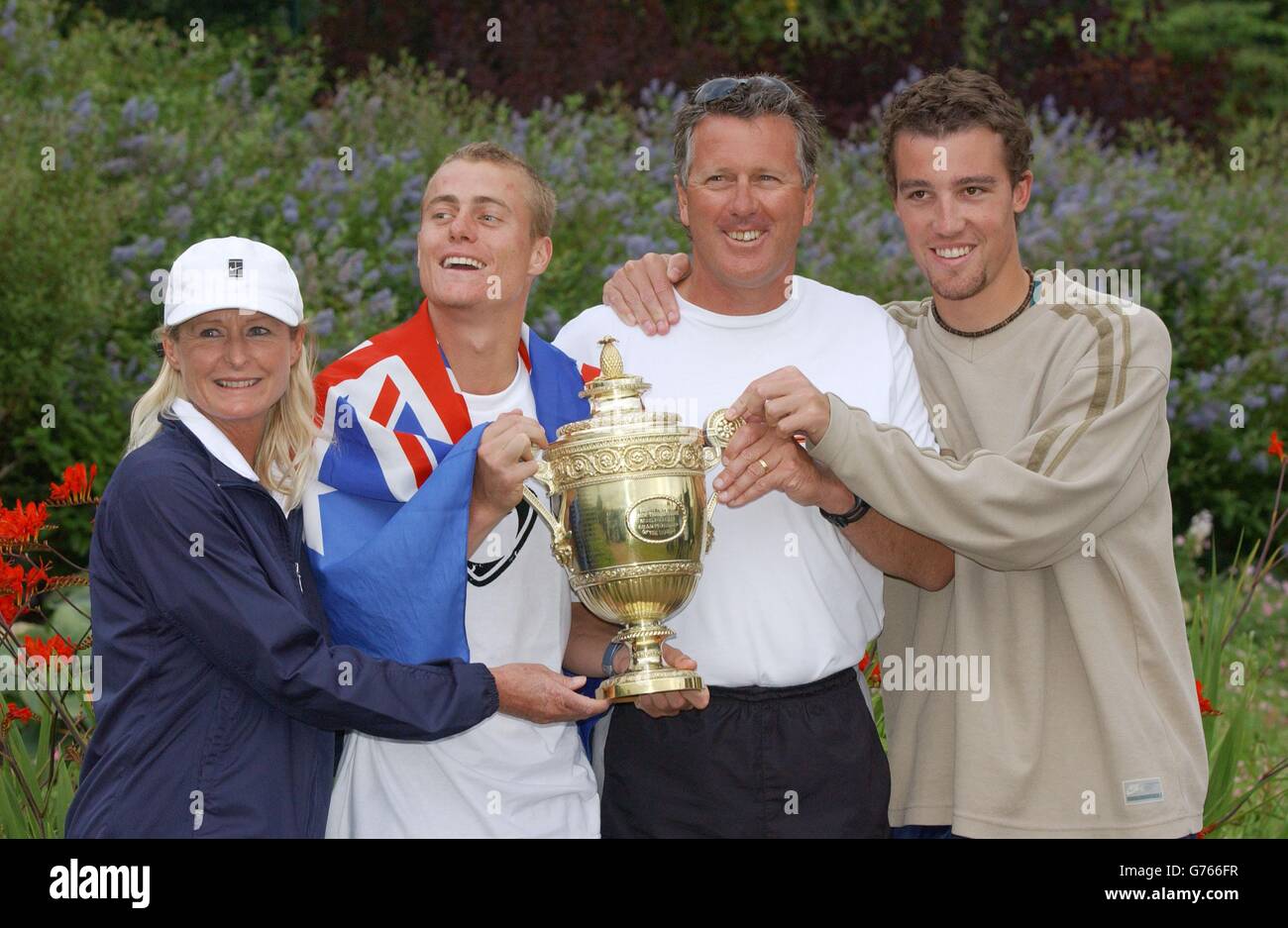 KEINE KOMMERZIELLE NUTZUNG. Wimbledon-Champion Lleyton Hewitt aus Australien zeigt seine Trophäe seinen Eltern Cherilyn und Glynn und seinem besten Freund Jason Hayden Eckerman (rechts), nachdem er David Nalbandian besiegt hat. * aus Argentinien im Finale der Herren-Singles in Wimbledon. Hewitt gewann in den geraden Sätzen 6:1/6:3/6:2. Stockfoto