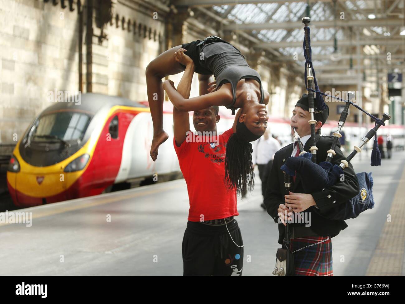 (Links - rechts) Rodney Isaac und Jessica Augustus von der OYO-Tanztruppe und dem Dudelsackspieler William Boyle fördern das YDance Commonwealth Youth Dance Festival während einer Fotoschau in der Glasgow Central Station. Stockfoto