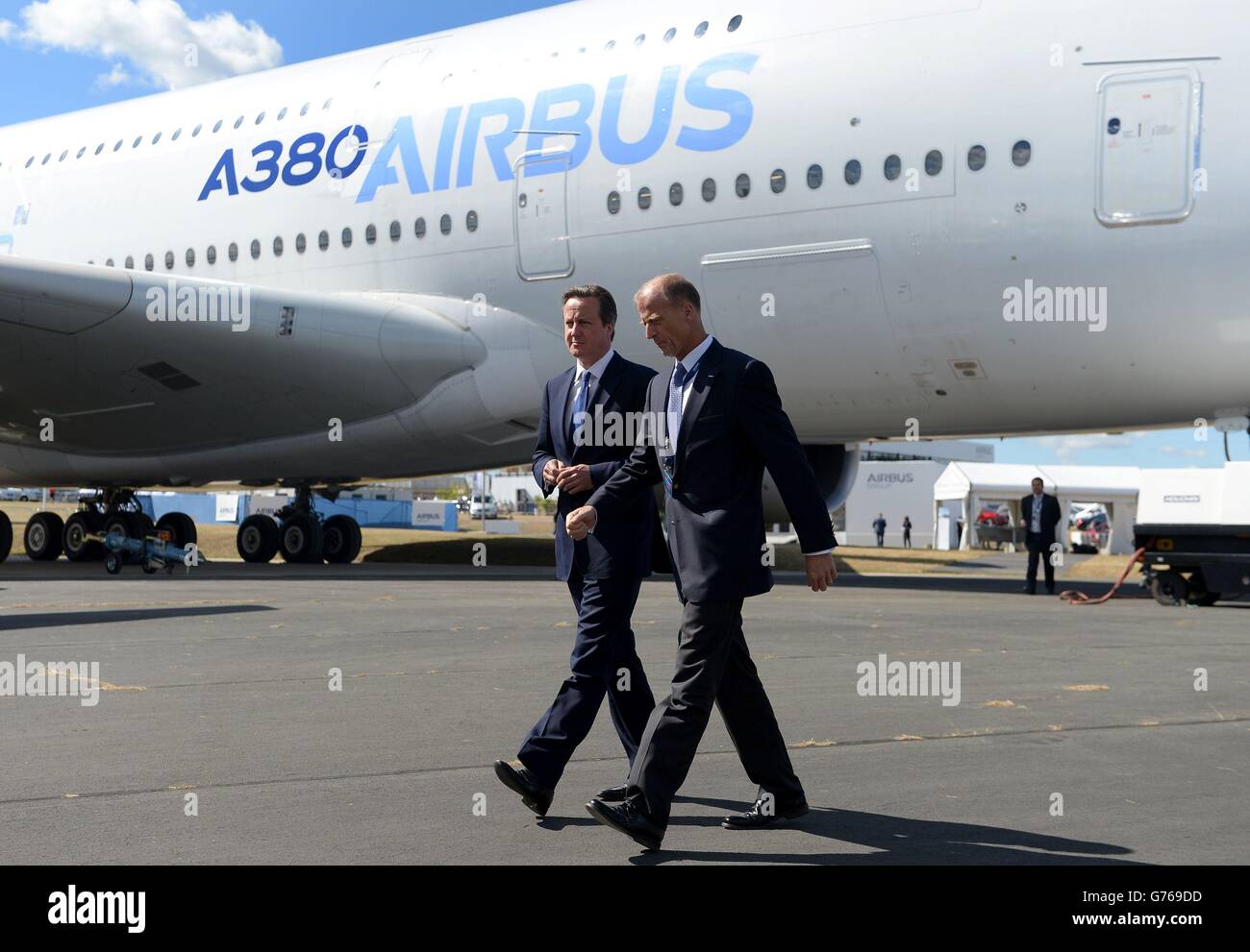 Premierminister David Cameron (links) und Tom Enders, der Vorstandsvorsitzende der Airbus Group, gehen bei einem Besuch der Farnborough Airshow 2014 in Hampshire an einem Airbus A380 vorbei, um den neuen Airbus A350 zu inspizieren. Stockfoto
