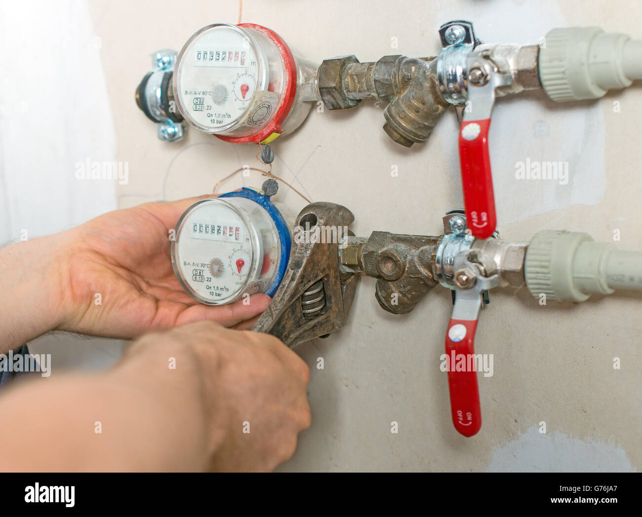 Männliche Klempner Befestigung Wasserzähler mit verstellbaren Schraubenschlüssel. Stockfoto