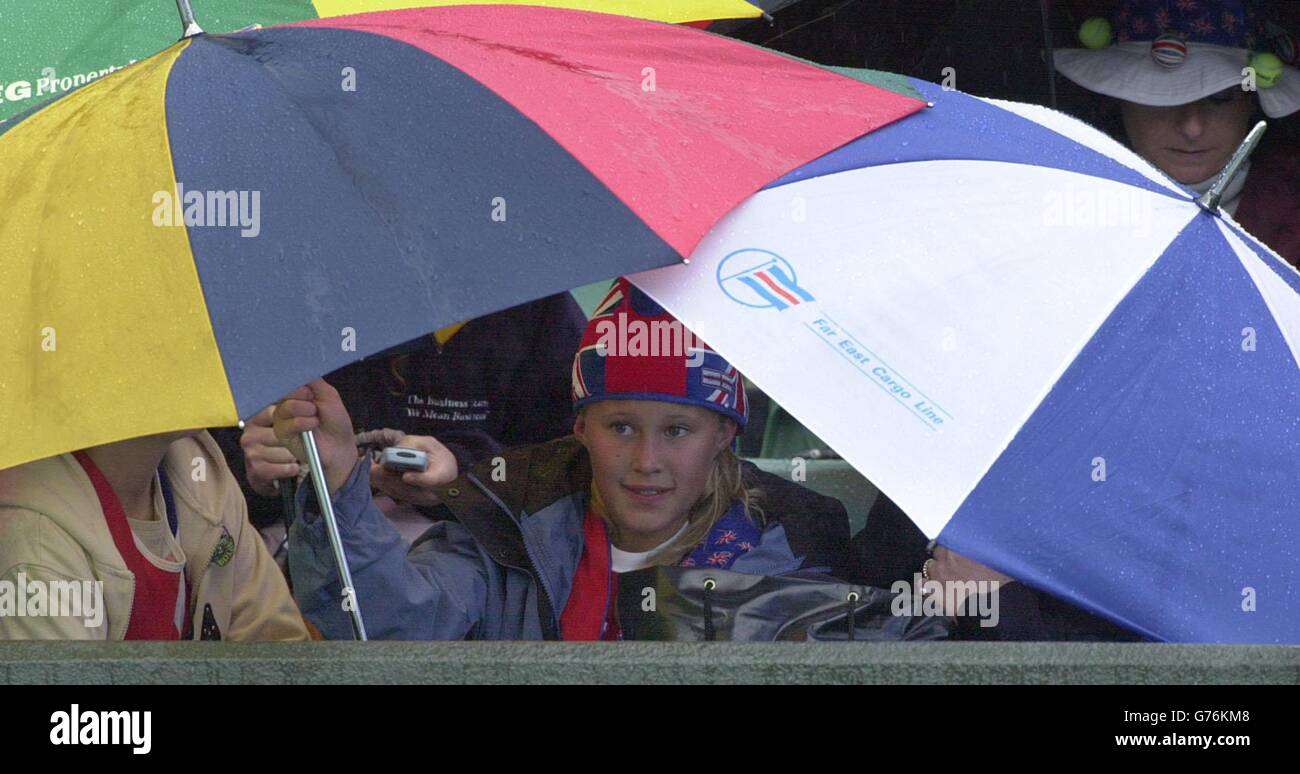 FÜR , KEINE KOMMERZIELLE VERWENDUNG. Tennisfans auf dem Court One in Wimbledon decken sich beim Spiel zwischen dem britischen Nummer-eins-Tennisstar Tim Henman und dem Schweizer Michel Kratochvil vor einem plötzlichen Regenschauer. *... in der vierten Runde auf Court One in Wimbledon. Stockfoto