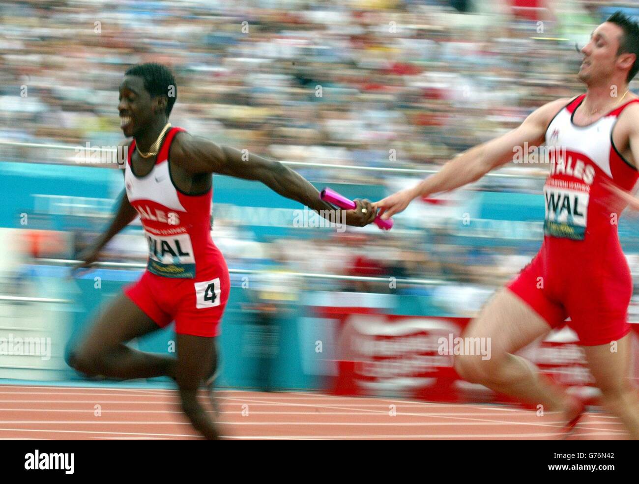 Der walisische Anker Christian Malcolm erhält den Staffelstab von Teamkollege Jamie Henthorn, als sich ihre Mannschaft für das Finale des 4 x 100 Meter großen Staffelfinales der Männer bei den Commonwealth Games in Manchester qualifiziert. Stockfoto