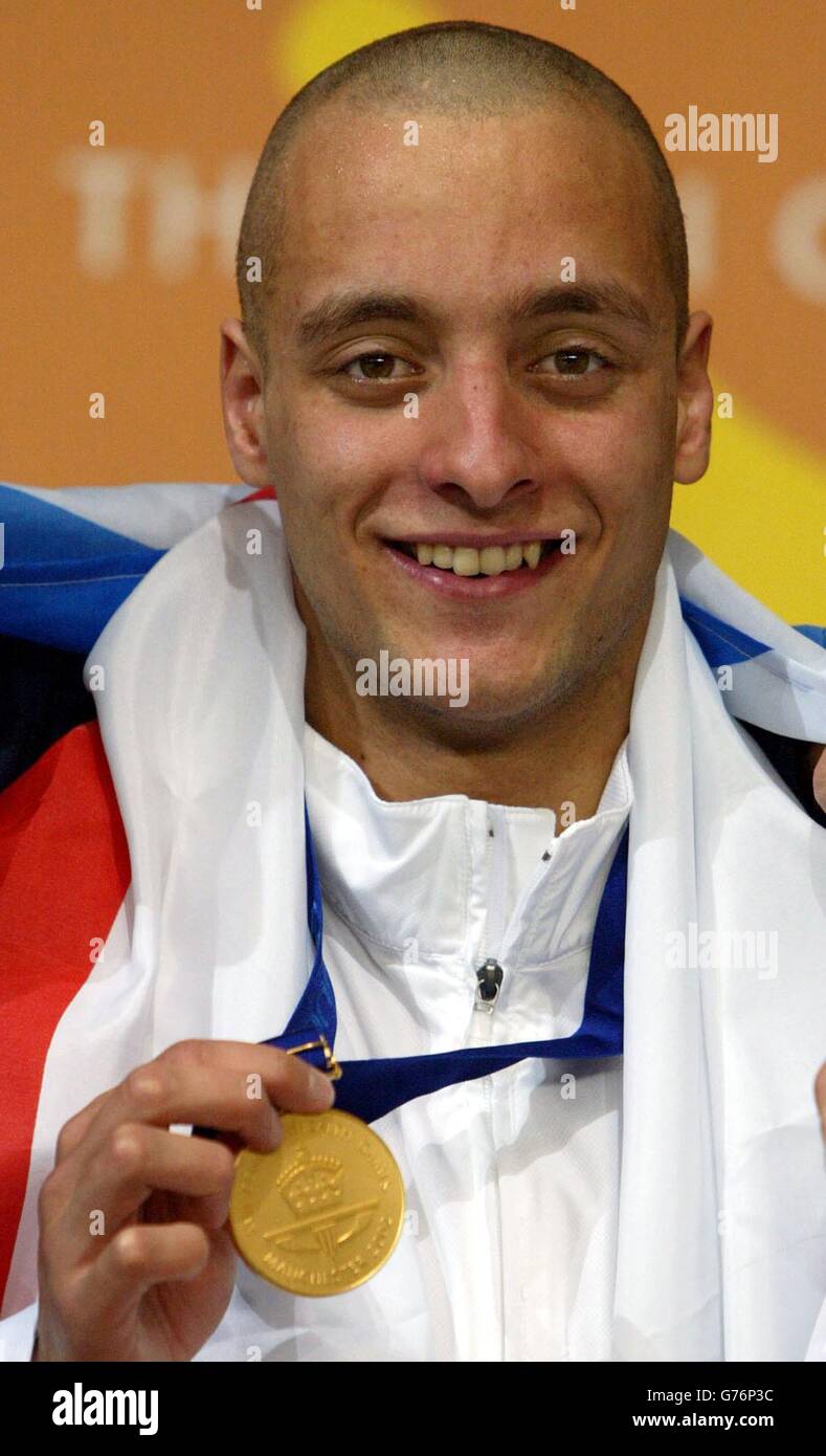 Der englische James Goddard posiert mit seiner Goldmedaille für Bilder, während er den 200-m-Rückenstrich der Herren bei den Commonwealth Games 2002 in Manchester feiert. Stockfoto