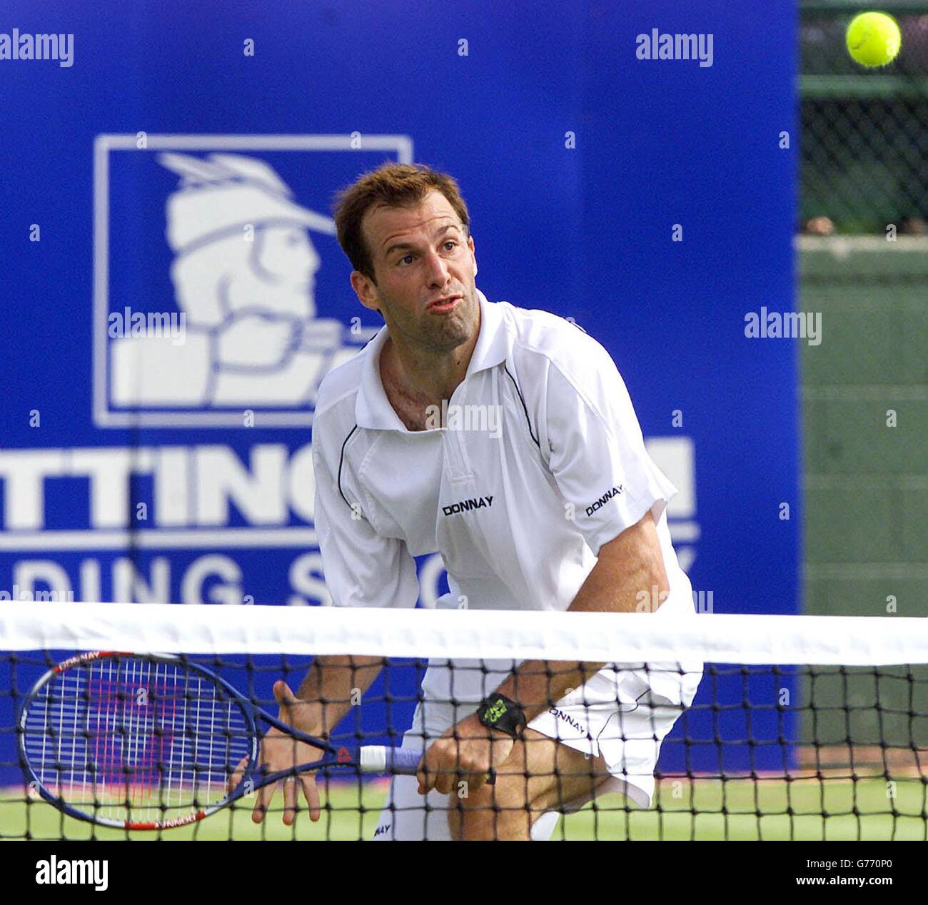 Der Großbritanniens Greg Rusedski beobachtet den Ball, während er aus der Nähe des Netzes bei seinem 4-6, 6-2, 6-1, 1. Runde Sieg über den Australier Todd Reid , bei den Samsung Open in Nottingham rollt. Stockfoto