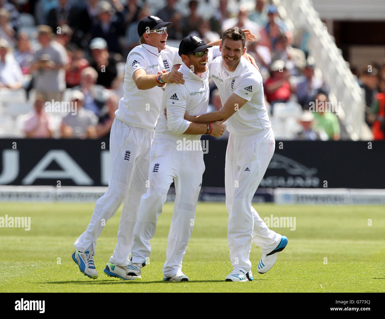 Englands James Anderson feiert, das Wicket der Indianer Cheteshwar zu nehmen Pujara mit seinen Teamkollegen Joe Root (links) und Ian Bell (Mitte), die den Fang nahm Stockfoto