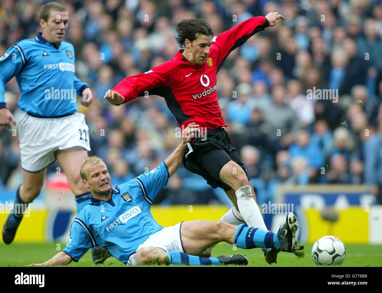 Ruud Van Nistelrooy von Manchester United wird von Gerard Wiekens von Manchester City (am Boden) während ihres FA Barclaycard Premiership-Spiels auf dem Maine Road Ground von Manchester herausgefordert. Endergebnis: Man City 3 man Utd 1. Stockfoto