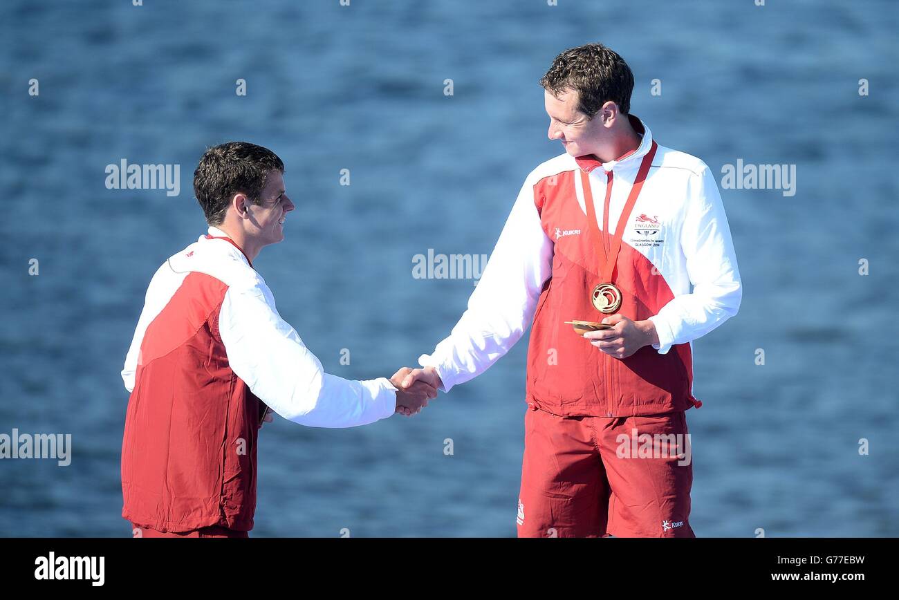 Englands Alistair Brownlee (rechts) feiert mit seiner Goldmedaille, nachdem er mit Bruder Jonathan, der Silber gewann, im Strathclyde Country Park während der Commonwealth Games 2014 bei Glasgow den Herren-Triathlon gewonnen hatte. Stockfoto