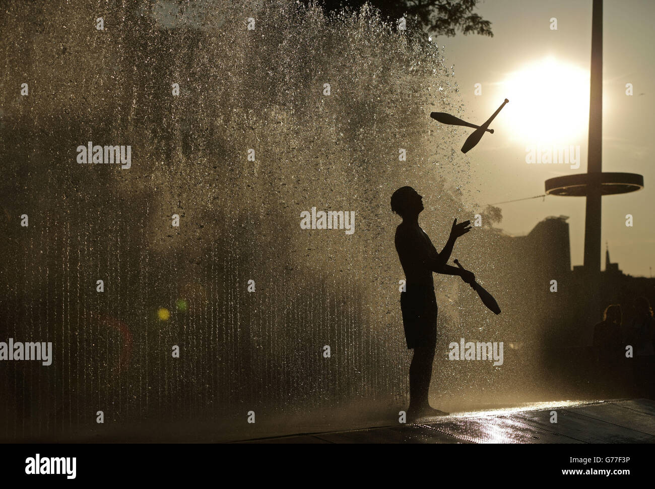 Adam Grace aus Eastbourne übt sein Jonglieren in Jeppe Hein's Appearing Rooms Water Fountain auf der Southbank in London. Stockfoto