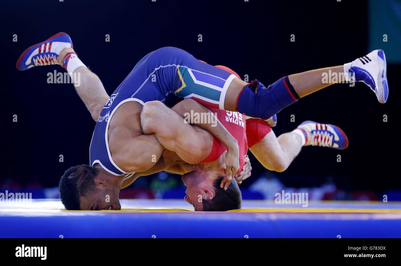 Englands Sasha Madyarchyk (rot) und Südafrikas Marno Plaatjies während des FS 61 kg Repechage Wrestling beim SECC, während der Commonwealth Games 2014 in Glasgow. Stockfoto