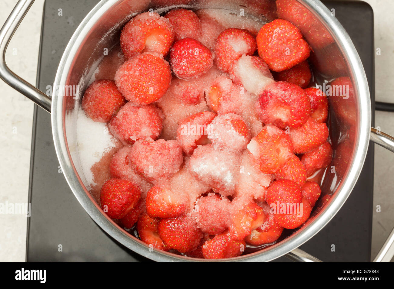 Erdbeeren und Zucker in einer Pfanne zur Herstellung von Marmelade Stockfoto
