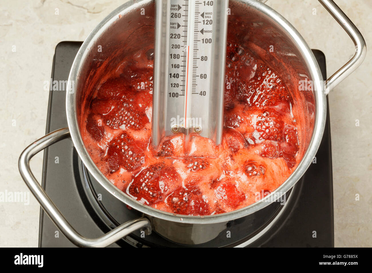 Thermometer messen die Temperatur der Erdbeermarmelade in einer Pfanne  Kochen Stockfotografie - Alamy
