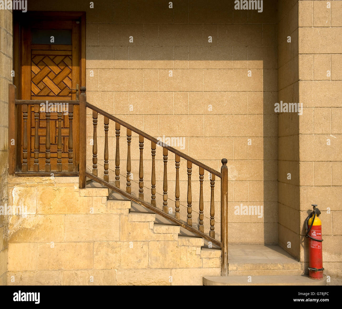 Treppe zum braunen verzierten Tür Stockfoto