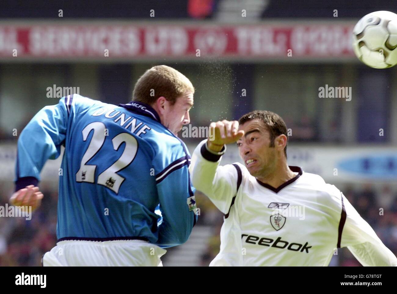 Richard Dunne (L) von Manchester City gewinnt einen Luftkampf mit Bolton's Youri Djorkaeff während ihres FA Barclaycard Premiership Spiels im Bolton's Reebok Stadium. Stockfoto