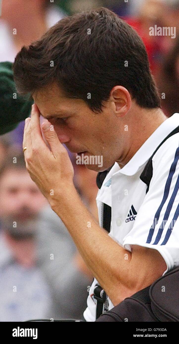 KEIN HANDY. Der Brite Tim Henman verlässt den Center Court, nachdem er im Viertelfinale der Männer bei den All England Lawn Tennis Championships in Wimbledon gegen Sebastien Grosjean aus Frankreich verloren hatte. * das Spiel wurde wieder aufgenommen, nachdem es wegen Regenunterbrechungen und schlechtem Licht abgebrochen wurde. Henman verlor schließlich 7:6/3:6/6:3/6:4. Stockfoto